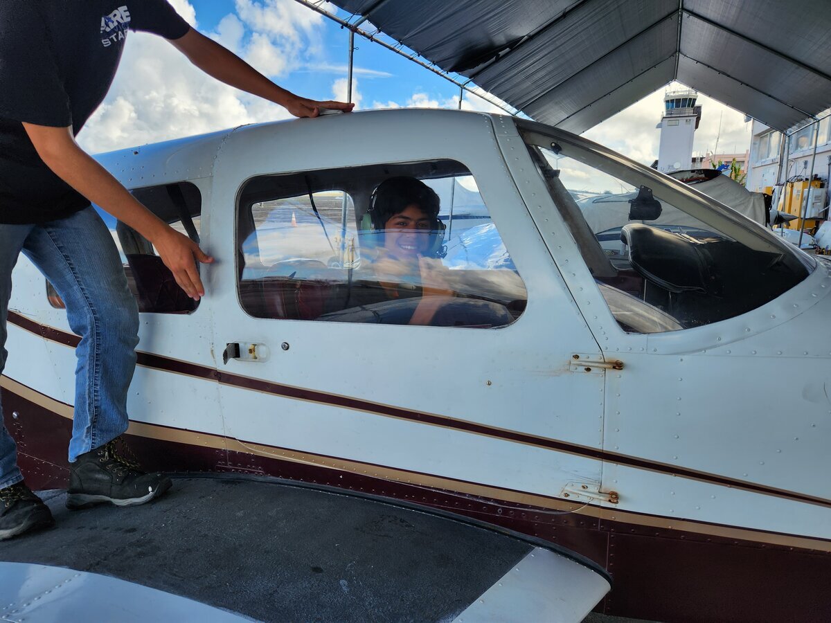 Jaden sitting in Cessna cockpit at Aire Services hangar