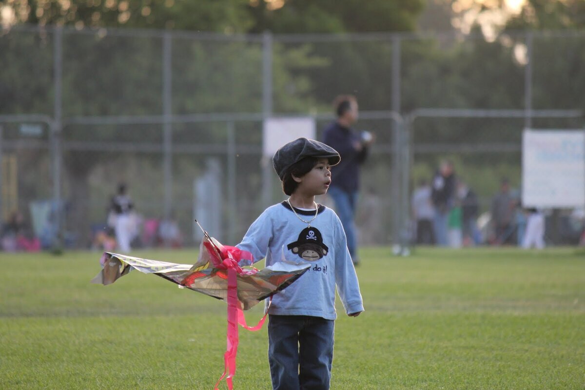 Young Jaden running across field flying a toy airplane